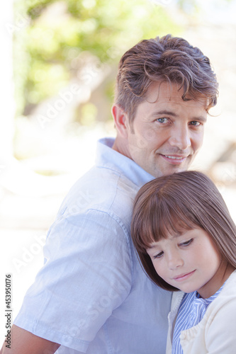 Father and daughter smiling outdoors