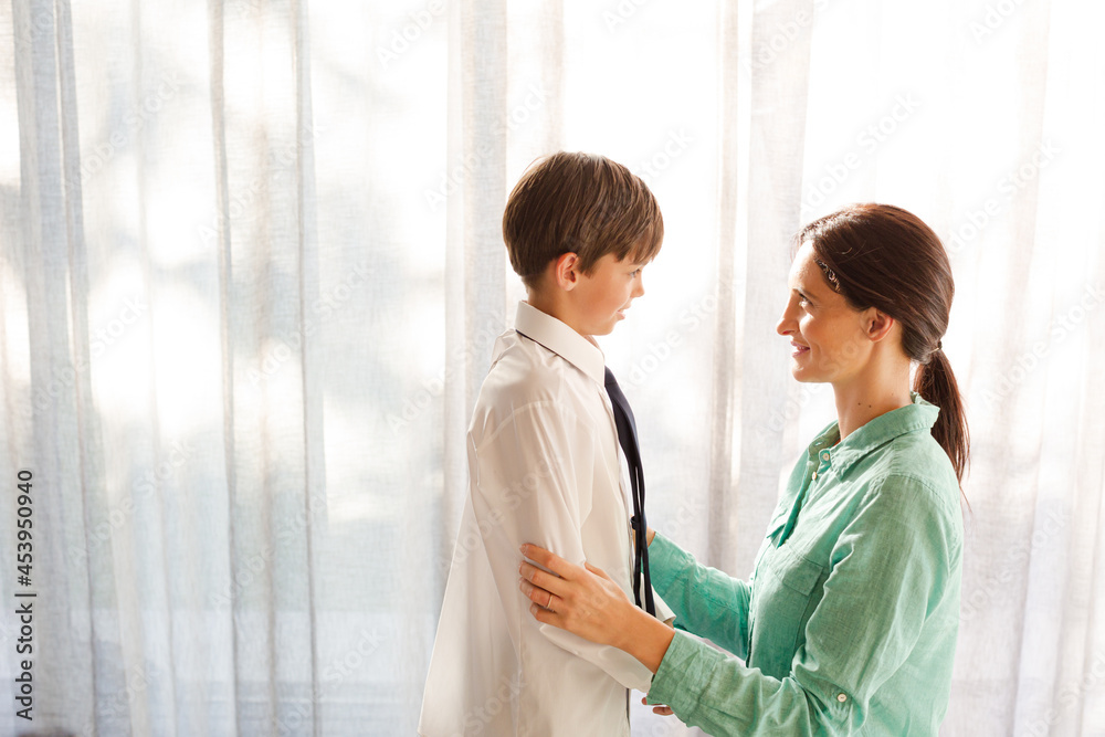 Fototapeta premium Mother and son touching foreheads at window