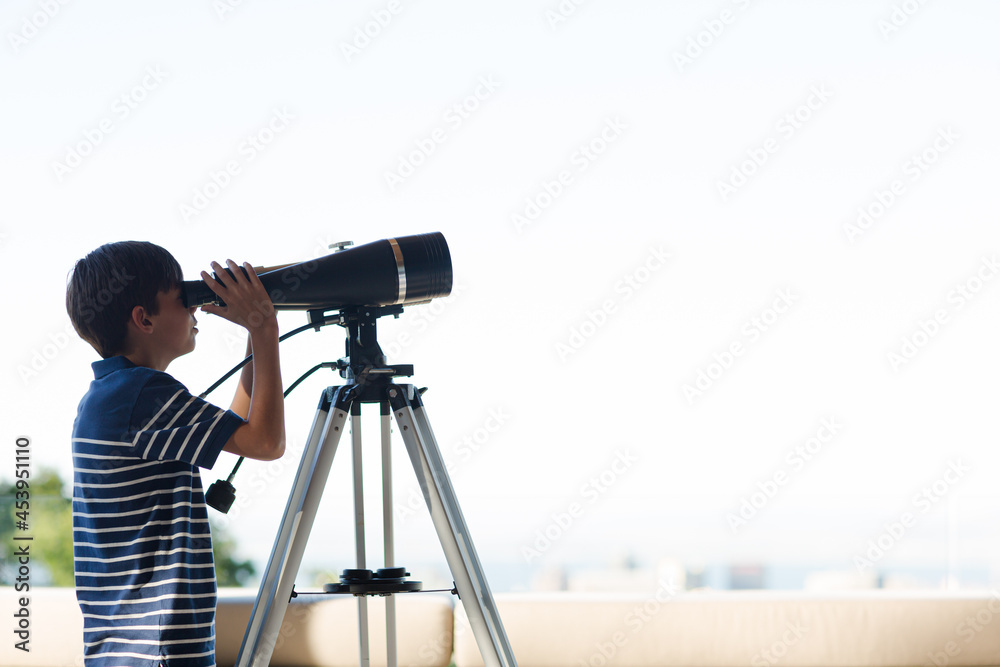 Boy using telescope outdoors Boy using telescope outdoors