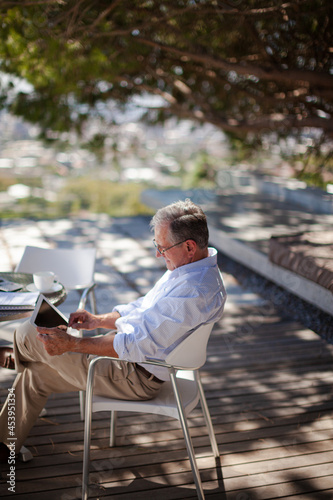 Older man using tablet computer outdoors © KOTO