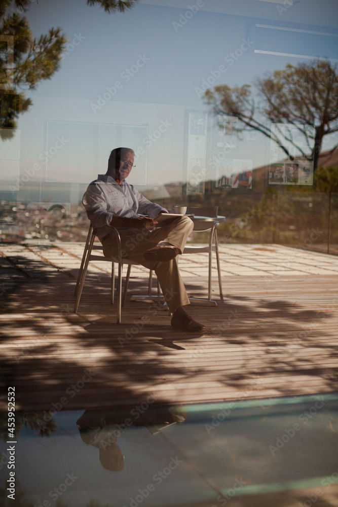 Older man using tablet computer outdoors Older man using tablet computer outdoors