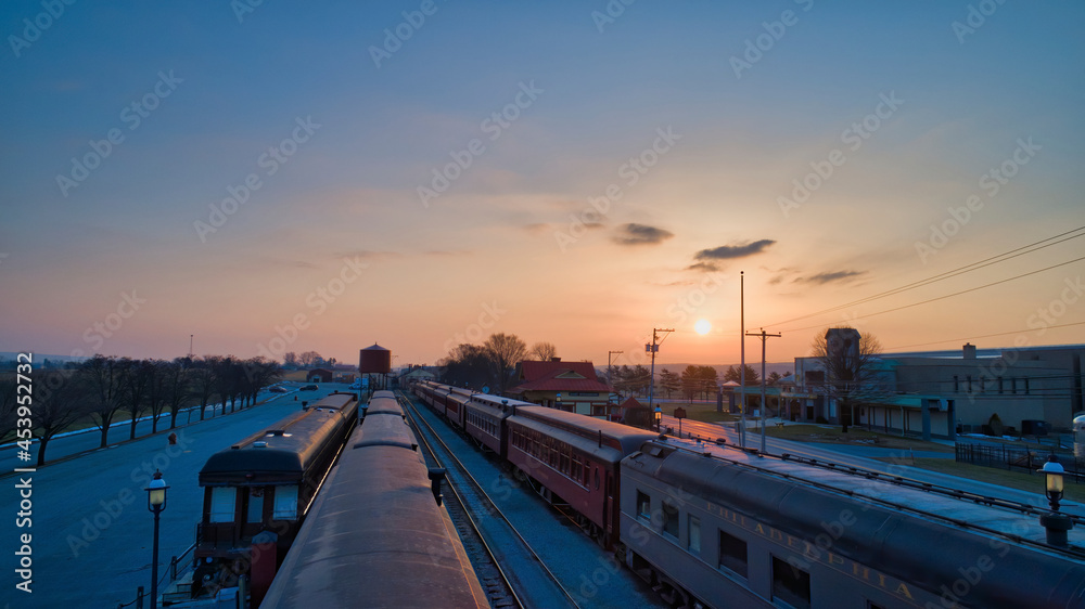 Sunrise With Blue, Red Sky and Clouds Looking Over a Train Station and Yard