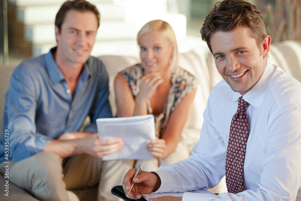 Financial advisor smiling with clients Financial advisor smiling with clients
