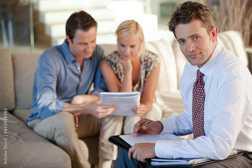 Financial advisor smiling with clients Financial advisor smiling with clients