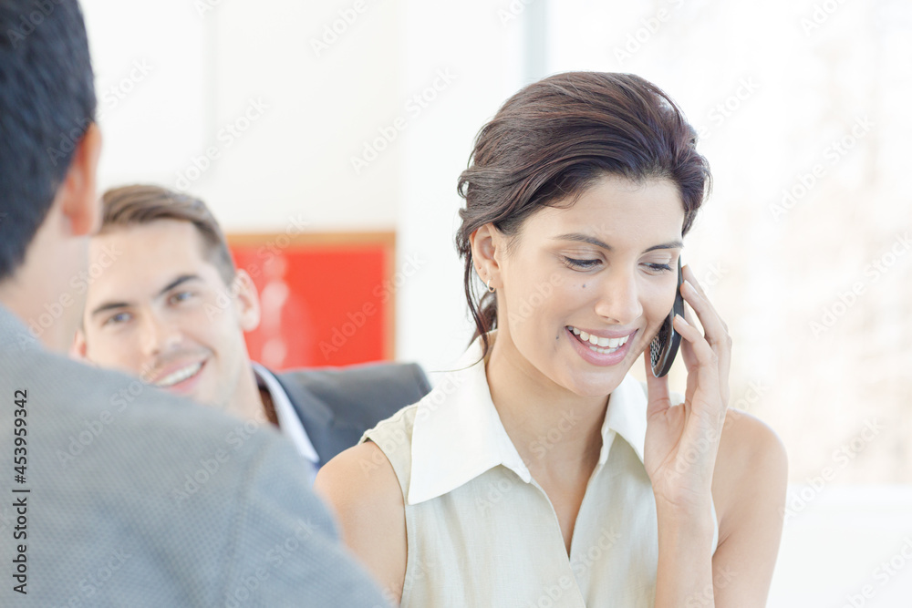 Businesswoman talking on cell phone in office Businesswoman talking on cell phone in office