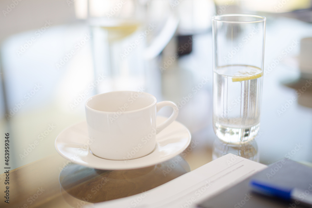 Coffee cup and water glass on meeting table Coffee cup and water glass on meeting table