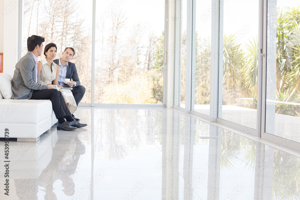 Business people talking on sofa in office Business people talking on sofa in office