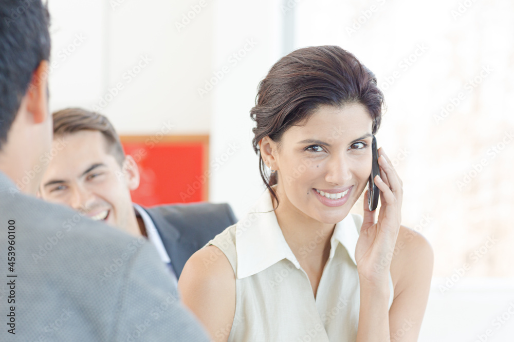 Businesswoman talking on cell phone in office Businesswoman talking on cell phone in office