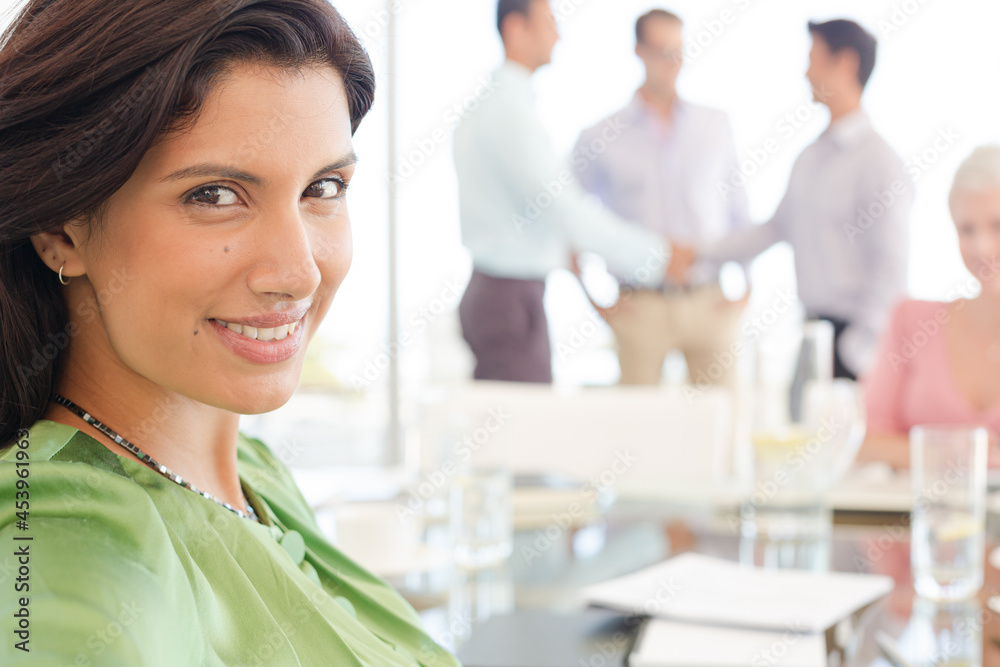 Businesswoman smiling at meeting table Businesswoman smiling at meeting table