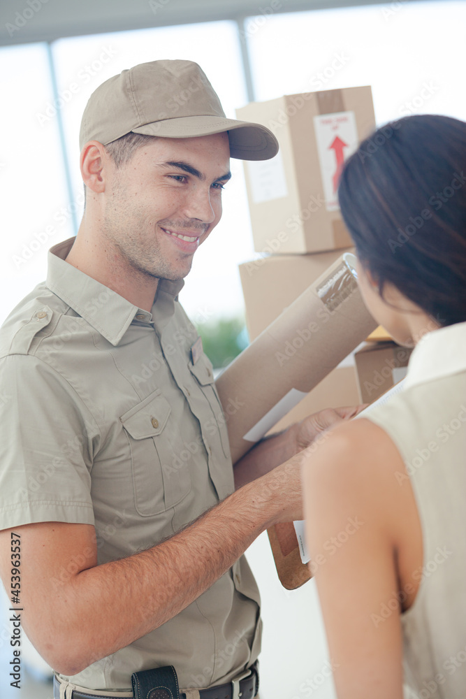 Woman signing for packages from delivery boy Woman signing for packages from delivery boy