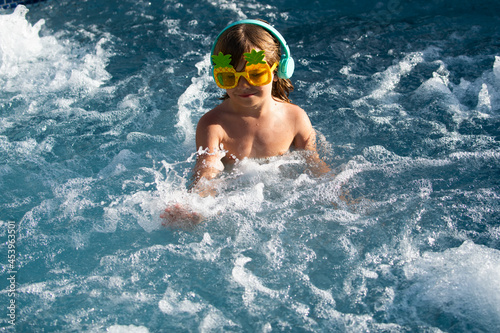 Happy young kid in swimming pool, smile relax face swimmer kid have fun activity. © Volodymyr