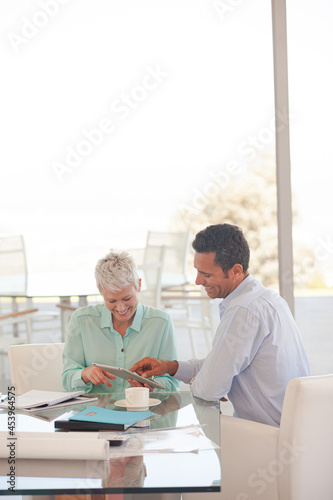 Business people using tablet computer on sofa