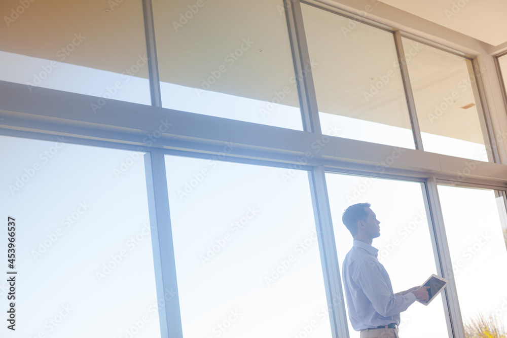 Businessman using tablet computer at window Businessman using tablet computer at window