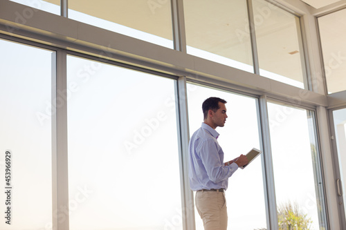 Businessman using tablet computer at window