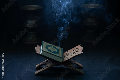 Quran in the mosque - open for prayers The black background of the Muslims around the world placed on a wooden board Quran in the mosque - open for prayers ,in low light