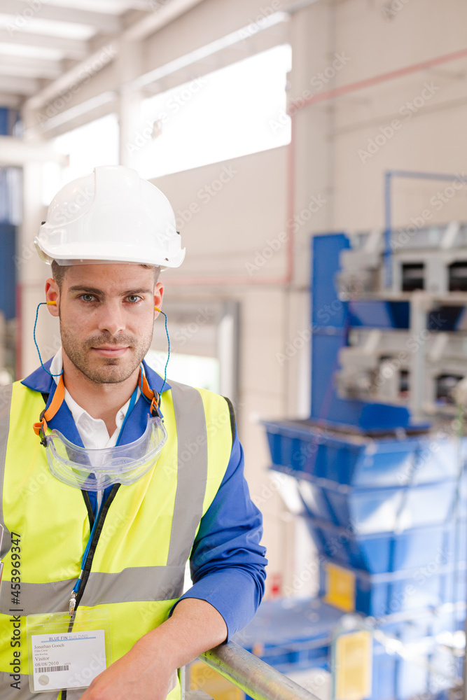 Worker wearing hard hat and ear plugs Worker wearing hard hat and ear plugs