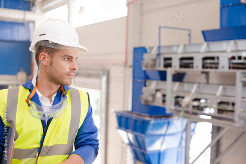 Worker wearing hard hat and ear plugs