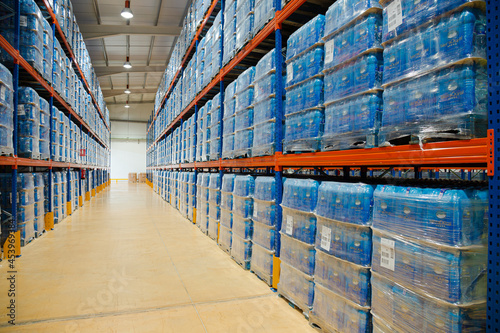 Pallets of water bottles on warehouse shelves