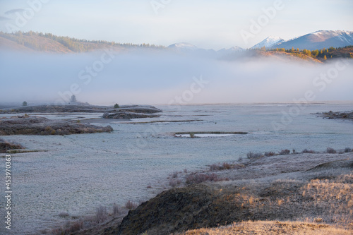 Altai river Kurkurek on Eshtykel plateau covered with morning fog. Grass under hoarfrost.