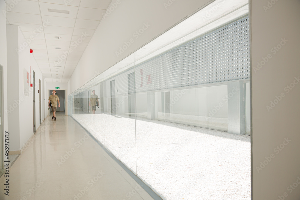 Man walking in corridor inside modern building Man walking in corridor inside modern building