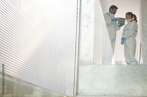 Scientists in clean suits using digital tablet © KOTO