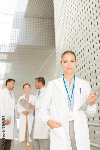 Female doctor with clipboard in hospital corridor