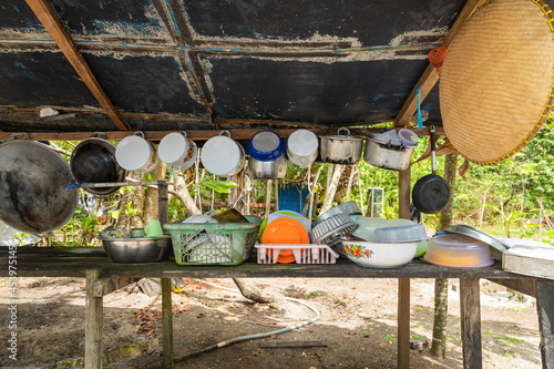 The bench of a humble kitchen, full of pots, boxes and miscellaneous things, on Gam Island, Raja Ampat, Indonesia photo