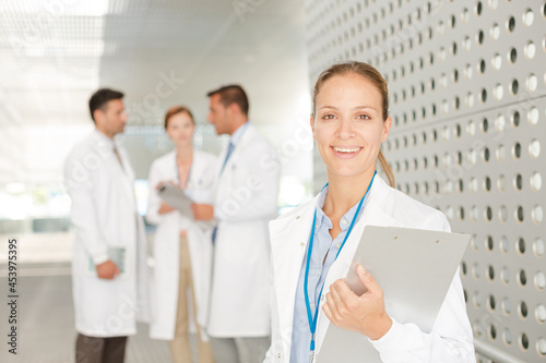 Doctor with clipboard in hospital corridor
