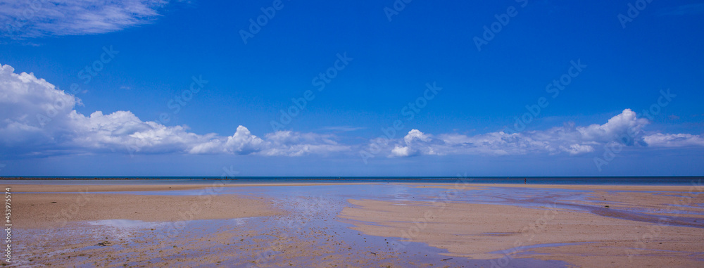 Tropical sandy beach and clear blue sea with beautiful sky with clouds. Summertime