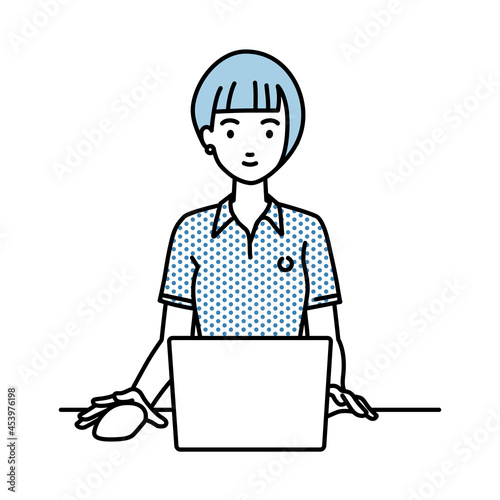 デスクで座ってPCを使っているポロシャツの女性
