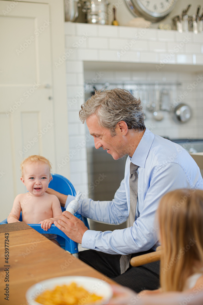 Obraz premium Father and children eating breakfast in kitchen