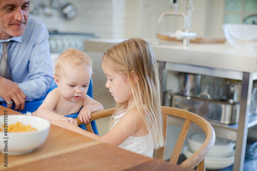 Father and children using digital tablet at table Father and children using digital tablet at table