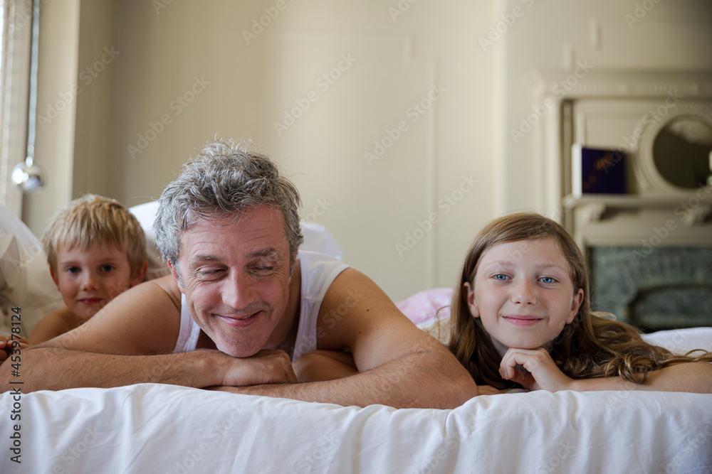Father and children relaxing on bed Father and children relaxing on bed