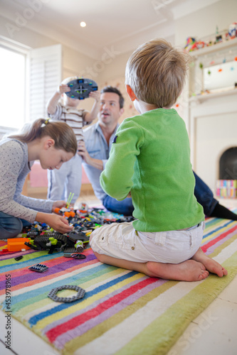 Father and children playing together with toys