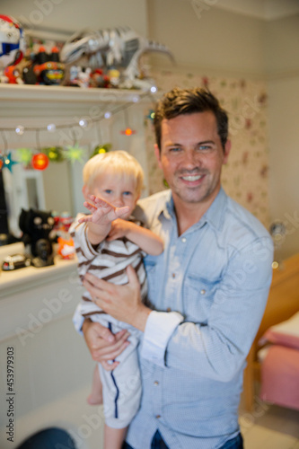 Father holding son in living room