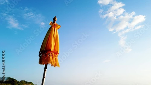 Clear and beautiful yellow Tedung traditional Bali umbrella with blue sky background and calm quite at ceremony photo