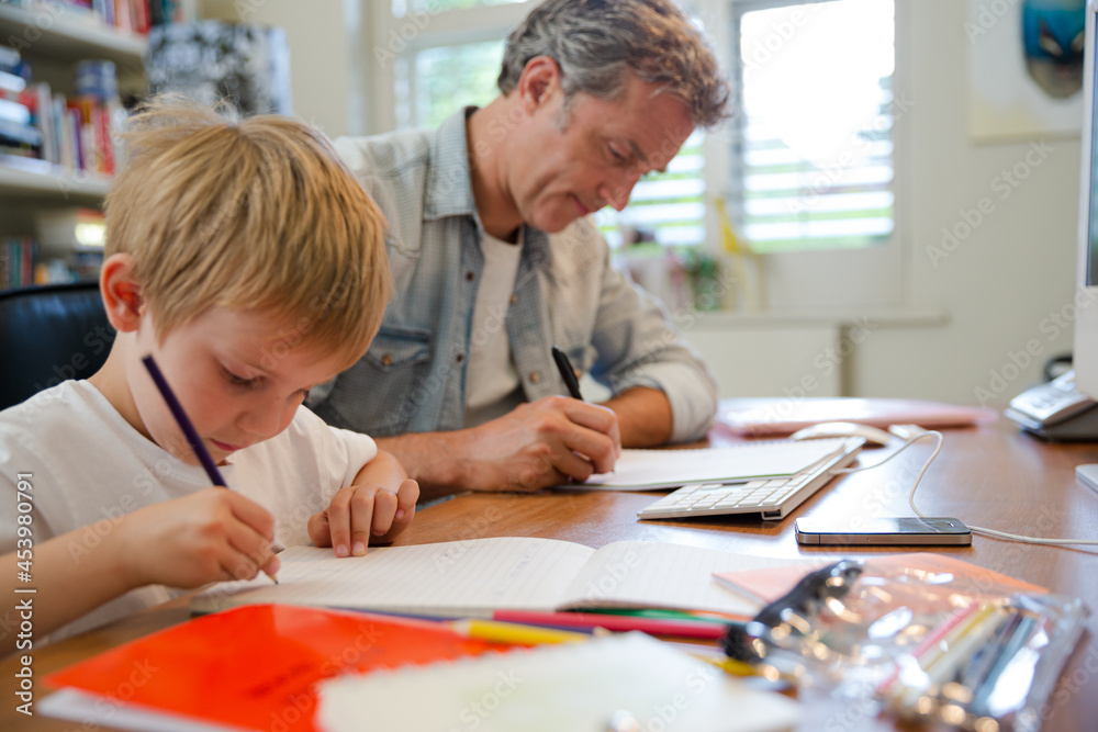 Father and son working in home office Father and son working in home office