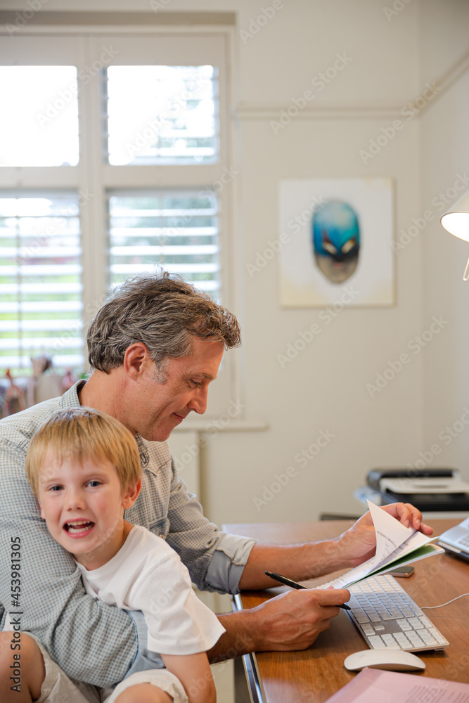 Father and son working in home office Father and son working in home office