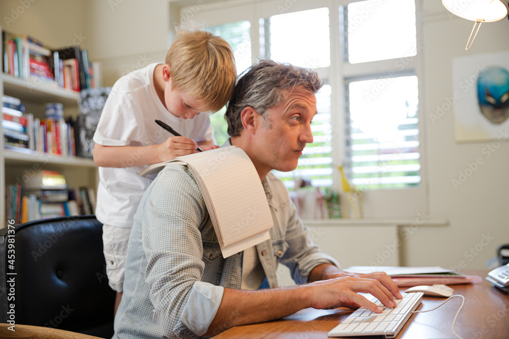 Boy hugging working father Boy hugging working father