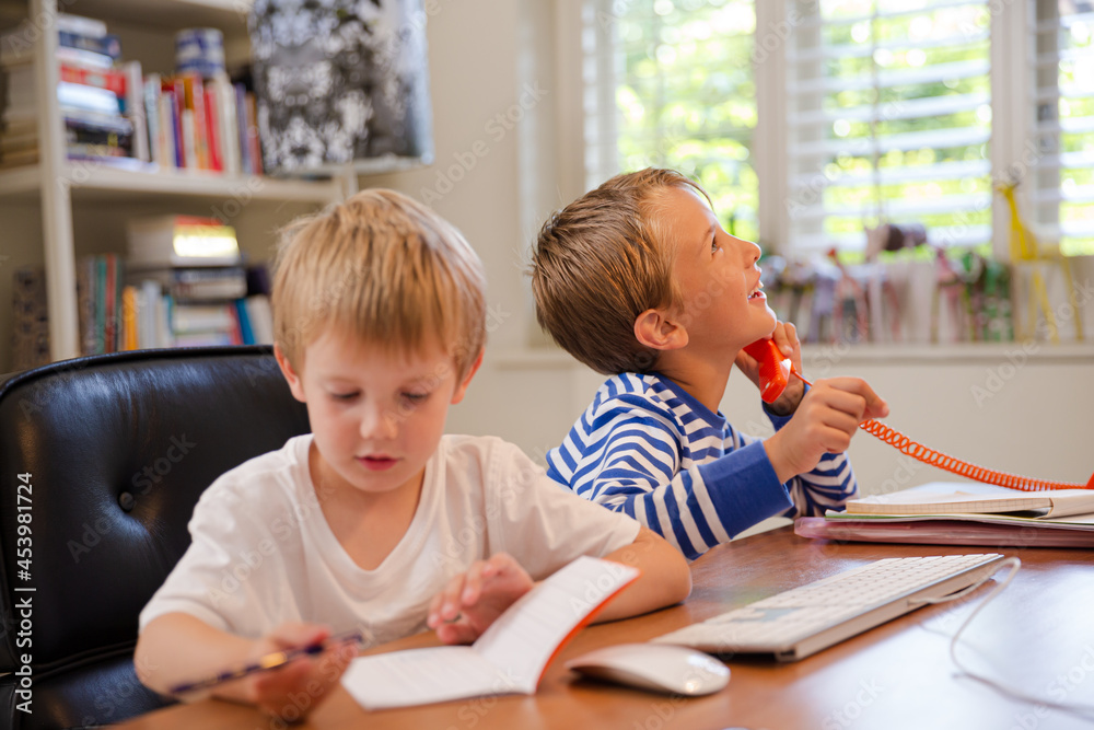 Boys using telephone in home office Boys using telephone in home office