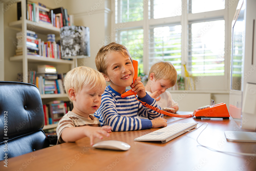 Boys using telephone in home office Boys using telephone in home office