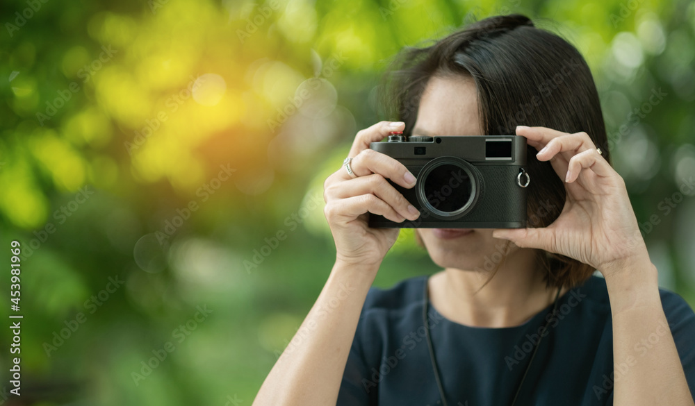 Asian woman holding a camera, professional photographer