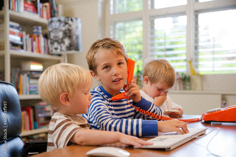 Boys using telephone in home office Boys using telephone in home office