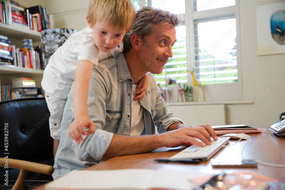 Fototapeta premium Boy hugging working father