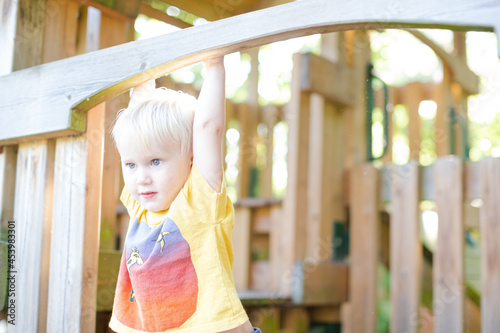 Boy playing on playset outdoors © KOTO