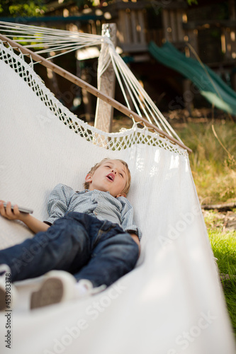 Boy using cell phone in hammock