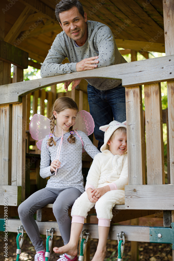 Fototapeta premium Father and children playing on playset