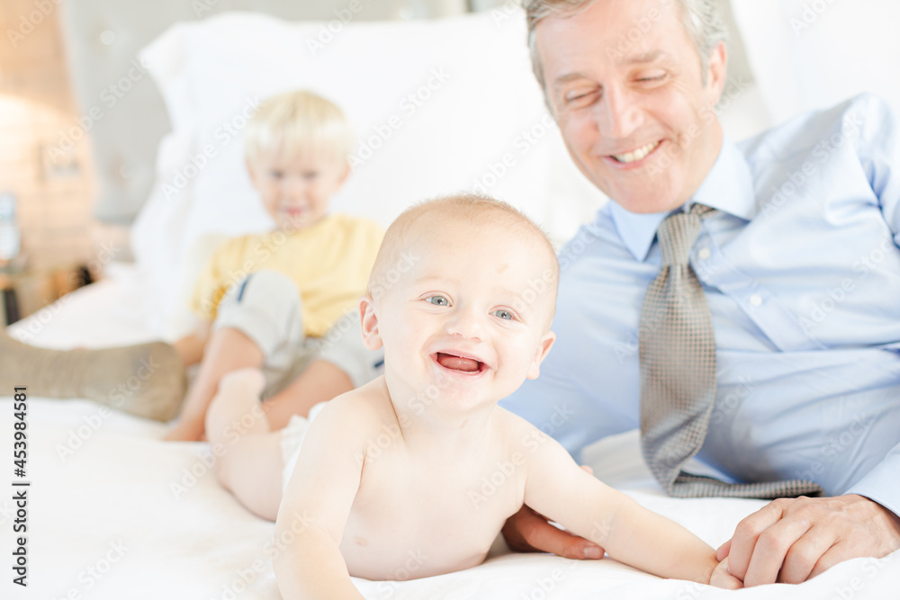 Father and children relaxing on bed