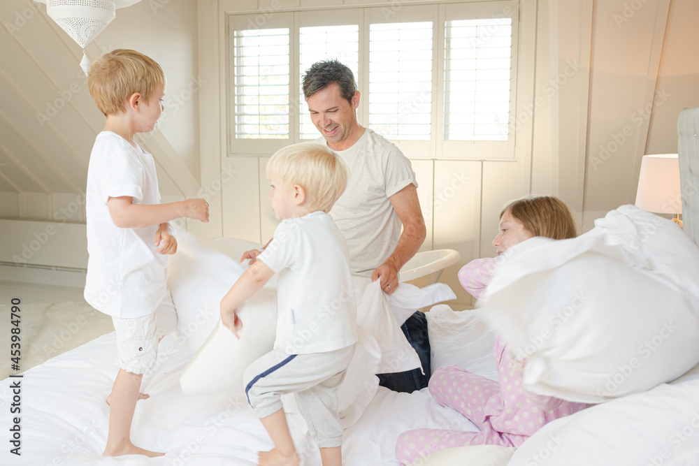 Father and children having pillow fight Father and children having pillow fight
