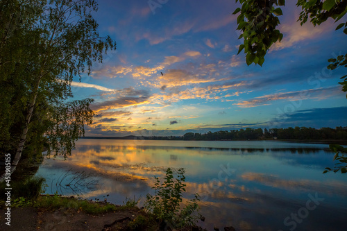 beautiful landscape of the water surface of the lake on a summer morning with light clouds in the sky reflecting in the water